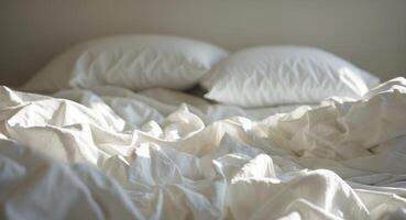 An unmade bed with pillows and sheets photo