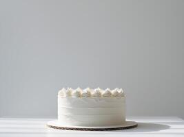 Minimalist White Cake with Creamy Frosting on a White Table, Light and Airy. photo