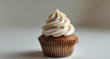 Delicious Vanilla Cupcake with Swirled Frosting, Brown Wrapper, on a Light Background photo