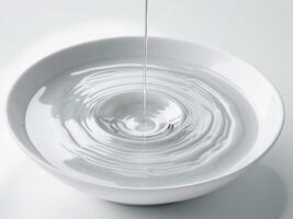 Water Dropping Into a White Bowl Creates Ripples a Minimalist Zen Image. photo
