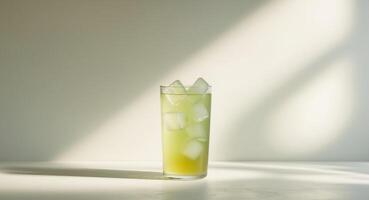 Refreshing Green Juice with Ice Cubes in a Glass on a Bright Background, Summer Time. photo