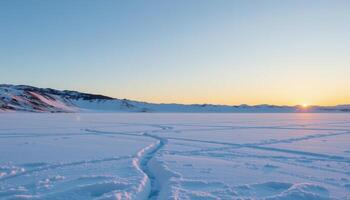 the soft glow of dawn slowly reveals a frozen tundra stretching endlessly beneath a pale blue sky. photo
