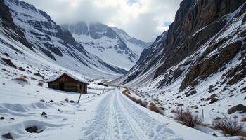 an abandoned mountain pass is half buried in snow, surrounded by wind swept cliffs. photo