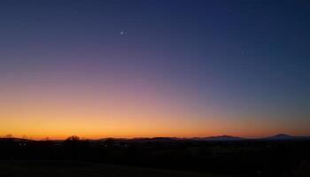 a faint glow appears on the horizon as twilight fades into night. photo