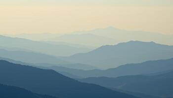 a soft haze blurs the distant ridges of a blue toned mountain range. photo