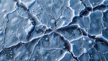 a network of ice cracks forms intricate patterns across a frozen lake. photo