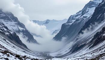 a mountain saddle between two snowy peaks, filled with drifting mist. photo