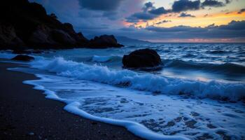 a twilight coastline where the sea glows faintly and waves lap the rock. photo