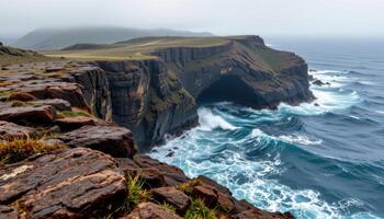 a rocky headland jutting into the ocean, lashed by waves and mist. photo