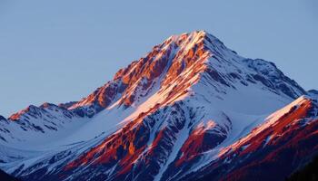 a snow dusted peak glowing in the golden light of the early evening. photo