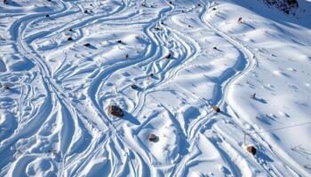 a snow blanketed slope marked only by rocks and wind carved patterns. photo