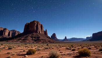 a remote desert landscape with towering rock formations and a clear, star filled sky at night. photo