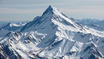 a remote mountain peak covered in snow and ice, towering above the surrounding landscape. photo