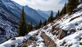 a secluded mountain pass where the first snow of winter blankets the rocky trail. photo