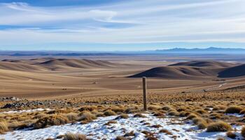 a remote tundra landscape with rolling hills and patches of snow under a vast, open sky. photo