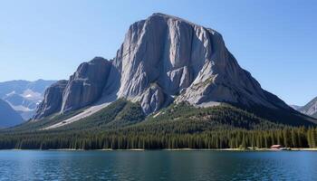 a massive granite outcrop rising from a still, reflective lake. photo