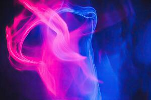 A blue and pink light is seen in the dark photo