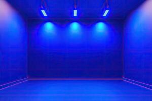 An empty room with blue lights and a wall photo