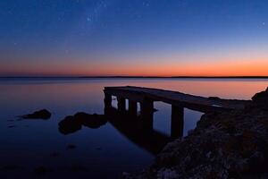 A pier at dusk with the milky in the sky photo