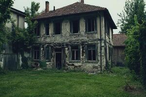 An old abandoned house in the middle of a field photo