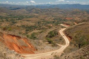 A dirt road winding through a mountainous area photo