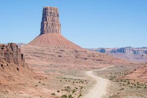 A dirt road that goes through a desert area photo