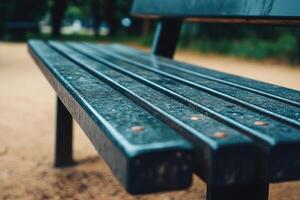 A bench with a wet seat and a dirt ground photo