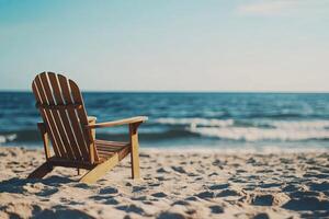 A wooden chair sits on the beach near the ocean photo
