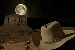 A cowboy hat on a rock in the desert photo