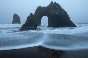 A foggy day at the beach with rock formations photo