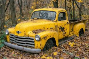 An old yellow truck sits in the woods photo