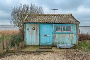 A small blue shed with a boat in front of it photo