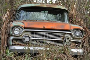 An old truck is sitting in the grass photo