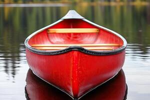 Red canoe on calm lake water. Close-up view of the boat's hull photo