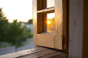 A wooden window with a sun setting behind it photo