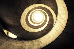 A spiral staircase with a light shining through it photo
