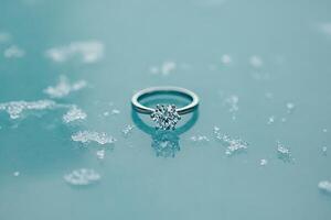 A diamond engagement ring on a blue surface photo