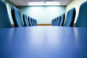 A conference table with blue chairs in a room photo