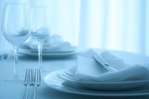 A white table with a white cloth and silverware photo
