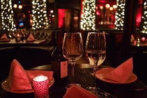 A table with two wine glasses and a plate of food photo