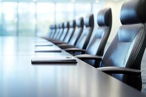 A long table with black leather chairs in a conference room photo