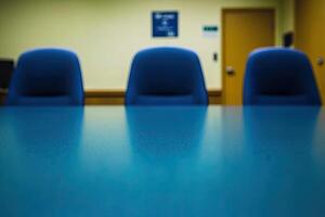 A conference table with blue chairs in front of it photo