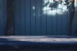 An empty wooden table in front of a blue wall photo