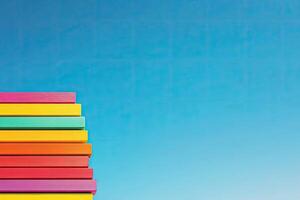 A stack of colorful books against a blue sky photo