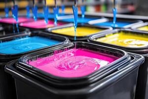 Colorful ink being poured into plastic containers photo