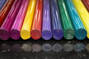 A row of colored pencils on a black surface photo