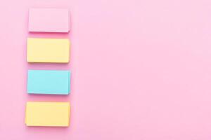 Three colorful sticky notes on a pink background photo