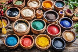 Colorful powders in wooden bowls on a wooden table photo