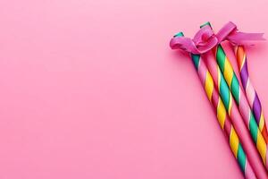 Three colorful birthday candles on a pink background photo