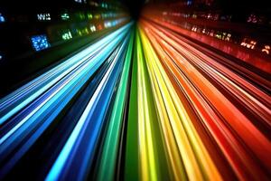 A rainbow colored light trail is seen in the dark photo